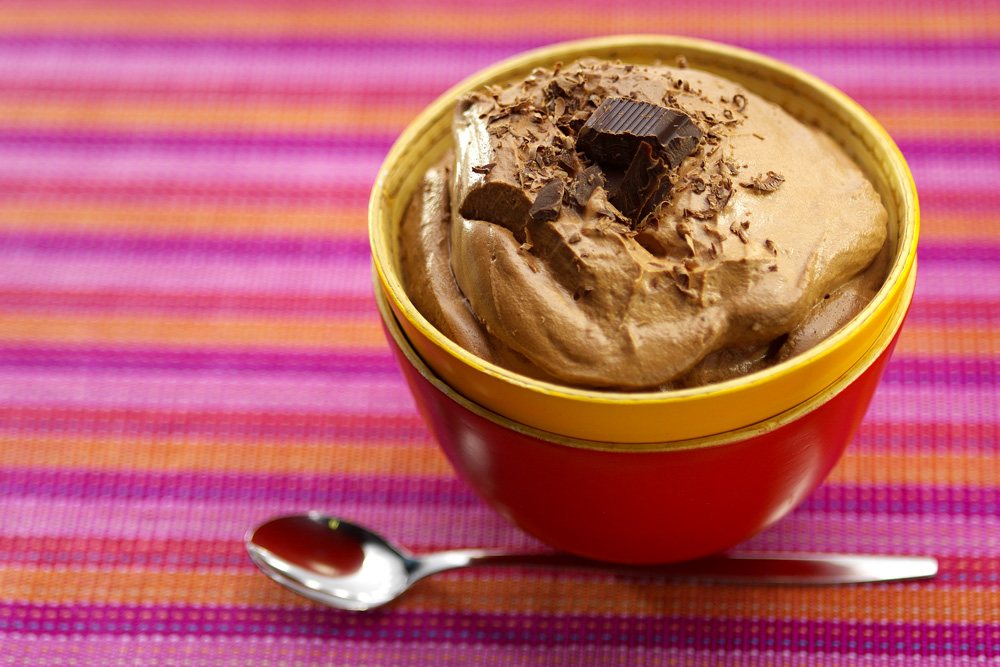 Chocolademousse met chocoladeschaafsel in een rode kom