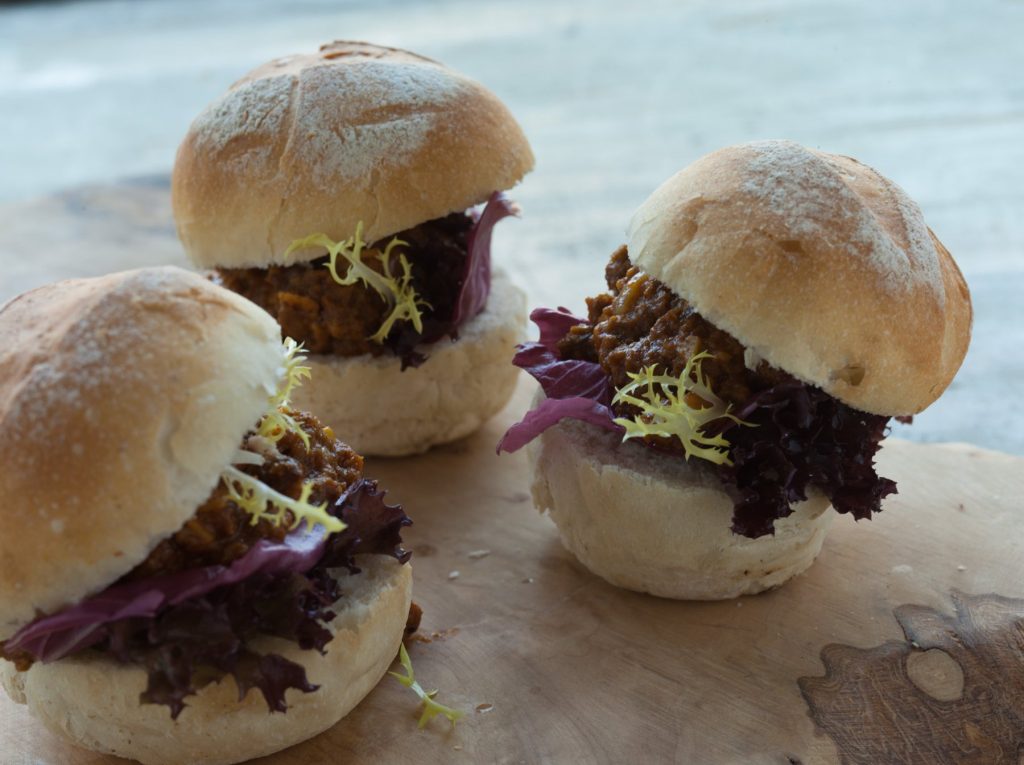 Broodjes met stoofvlees, radicchio en frisée op een houten plank