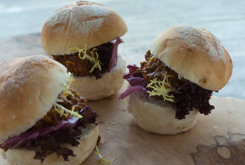 Broodjes met stoofvlees, radicchio en frisée op een houten plank